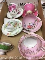 Top view of 5 assorted china cups and saucers with floral patterns in varying pink, white, and green color schemes