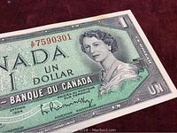 Close-up of the top right portion of the 1954 Canada one dollar note showing the portrait of Queen Elizabeth II and serial number.