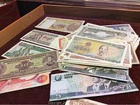 Pile of assorted world currency notes spread out, showing diverse currencies including Vietnam Dong and others