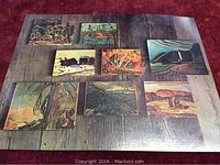 postcard displaying small paintings printed against weathered barn boards