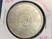 Front side of the 1964 Canadian silver dollar coin showing the central emblem and inscriptions.