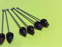 Photo showing 5 mini cheese forks with carved teak wood mouse heads attached atop metal forks. Each mouse head has painted colored eyes (blue and green) and black ears.
