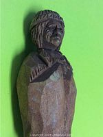 Side view of vintage carved wooden Native figure showing detailed facial features and attire