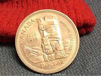 Close-up of the totem pole side of the 1958 Canada silver dollar coin showing the intricate design and inscriptions.