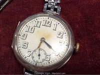 Front view close-up of white enamel dial with Arabic numerals and blue steel hands