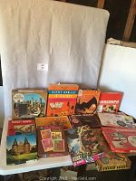 Full view of the vintage puzzles and science kit on table, showing puzzle boxes including cityscape, castle, Star Wars, Creepy theme, and Spirograph sets laid out.