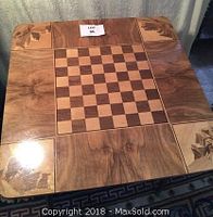 Top view of the square wood chess table with checkerboard playing surface and decorative corner inlays.