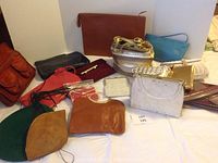 Full overview of all small purses and two hats arranged on white surface