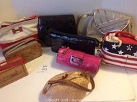 Photo showing eight assorted women's purses arranged on a white surface, displaying variety of colors, materials, and designs.
