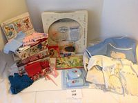 Photo of vintage doll clothes, baby clothes, vintage toys, and related items arranged on a surface
