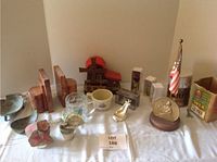 Full lot view showing Swedish stove, bookends, mugs, glass figurines, model barn, and other decorative items.