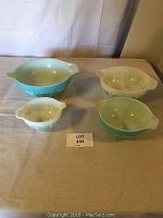 Four Pyrex nesting bowls arranged with labels, showing different sizes and the Amish Rooster Butter pattern.