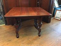 Front view of walnut tabletop and carved pedestal base