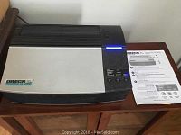 Oreck XL Professional air purifier with quickstart guide on top of wood surface