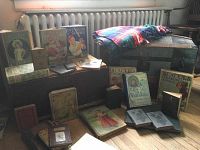 Closed humpback travel trunk with oak straps and leather handles, assorted books arranged in front