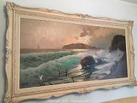 Oil painting in ornate cream-gold frame hanging on wall