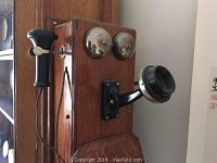 Front-angle view showing oak case, dual bells, swing-out mouthpiece and hanging earpiece