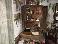 Overall view showing cabinet section on workbench, chisels hung on wall, clamps on side, and tabletop tools.