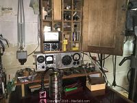 Workbench view showing wooden cabinet compartments and analog test panel mounted