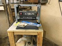 Front view of planer on wooden table with accessories on top