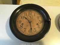 Front view of clock with bezel closed showing dial and brand marking.