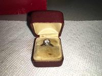 Opened red jewelry box displaying ring from above