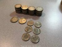 Stacks of 20 Dinara coins in four piles with six 10 Dinara coins laid out in front.
