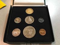 Seven-coin proof set displayed in black velvet-lined case