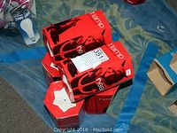 Six red Sylvania heat lamp bulb boxes stacked on a blue surface.