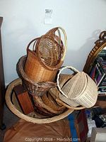 Photo showing stacked wicker baskets of various sizes and a small lidded basket with handle on top.