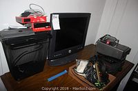 Photo showing Dell LCD monitor, shredder, camera, and electronic items on a table.