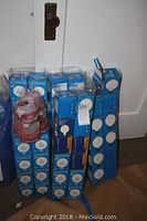 Overview of multiple boxes of new globe shape 40 watt incandescent bulbs in sealed original packaging including blue and purple Mood Glo brand boxes.