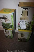 Photo of four boxed Sylvania Spot Gro adjustable plant fixtures standing upright on carpeted floor.