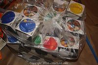 Multiple boxes of Sylvania 100 watt outdoor floodlights in various colors including blue, red, green, yellow, and orange, all wrapped together in plastic.