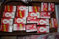 Overhead view of multiple boxes of Sylvania soft white light bulbs in assorted wattages including 40W, 75W, and 100W packed together inside a cardboard box.