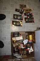 Overhead view of various packaged doorbell push buttons, chimes, and hardware parts scattered on the floor and in a box.