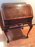 Front exterior full view of desk with curved fall-front closed and cabriole legs