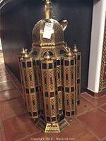 Full view of the brass Moroccan ceiling light fixture with hexagonal shape and colored glass panels.