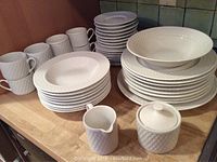 Full view of all 44 pieces including stacked dinner plates, soup bowls, cups, saucers, creamer and sugar set, and platters.