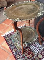 Photo of antique two-tiered table showing wooden frame and brass tray shelves with raised beaded border.