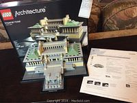 Model built showing detailed LEGO replica of the Imperial Hotel with beige and green bricks. Box in background displays LEGO Architecture branding and set number.