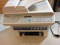 Side angle view of the Samsung SCX-4521F showing the full device including paper feed and output trays.