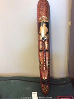 Full frontal view of the elongated wooden mask showing detailed painting and carving.
