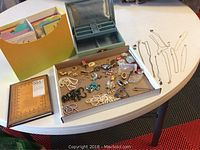 Full overview of the lot showing greeting cards organizer, jewelry box, assorted jewelry pieces, and notebook.