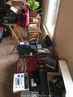 Wide overview of lot showing multiple items including drafting tools, computer parts, cassette players, and electronic chess game box.