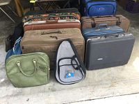 Front view showing 7 suitcases arranged in two rows with 5 bags in front, including a green handbag and Delta soft case