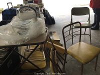 Photo showing four folding chairs with yellow vinyl seats, Samsonite metal fold-up chair, yellow anti-static mat on the floor, and Rival stand mixer on a table wrapped in bubble wrap.