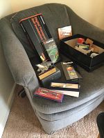 Upholstered chair with various items placed on it, indicating contents are not included.