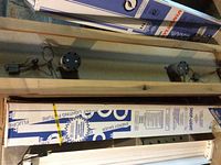 Photo of boxed Sears shop light 48 inches with visible packaging and two round components in wooden crate