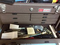 Front view of the Sears Craftsman tool chest showing the closed top lid and partially open drawers with tools inside.
